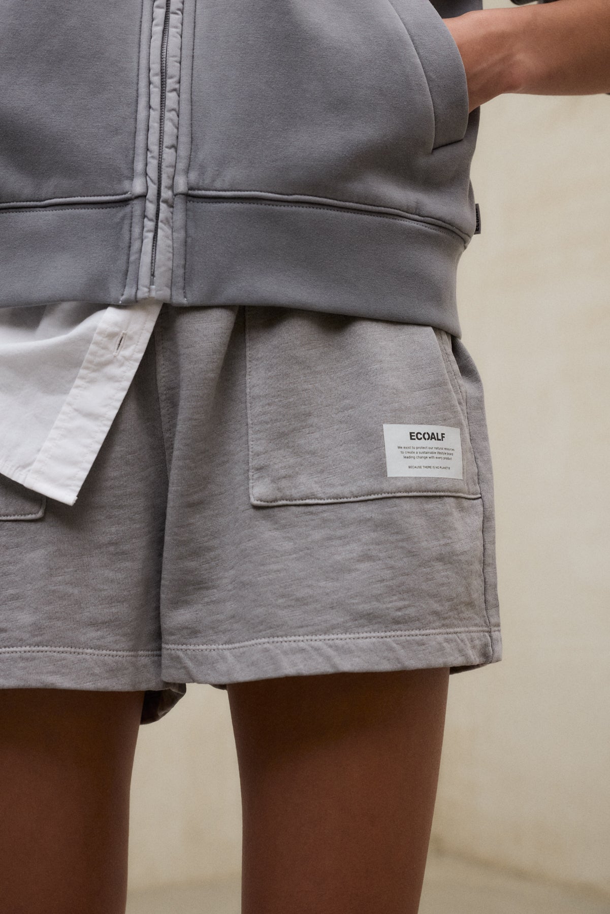 Primer plano de shorts grises sostenibles Ecoalf mostrando el detalle de la etiqueta distintiva de la marca.
